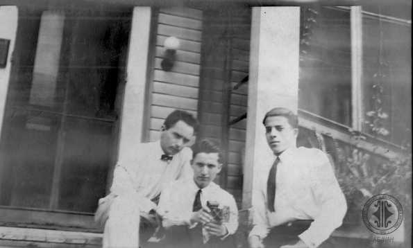 Tres jóvenes en entrada de casa.